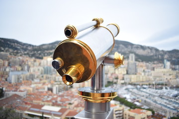 Golden and white telescope and Monaco landscape and panorama behind