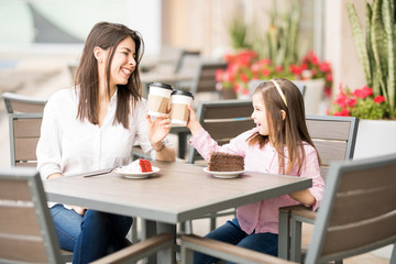 Happy mother and daughter enjoying their coffee