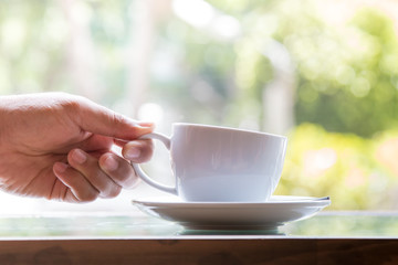Businessman taking coffee cup for drinking in coffee cafe