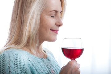 Closeup portrait of female customer drinking red wine with eyes closed.