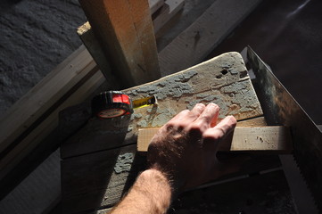 man saws a wooden beam