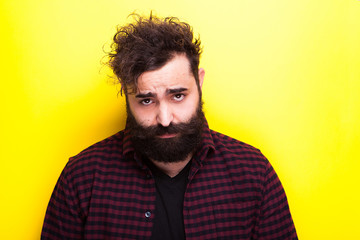 Man with a long beard looking at the camera on yellow background