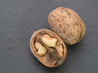 Single walnut on black stone background. Healthy food