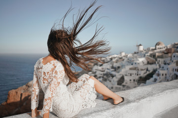 Fototapeta na wymiar Woman in white dress on Santorini island
