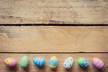 Colorful easter egg on wood background with space.