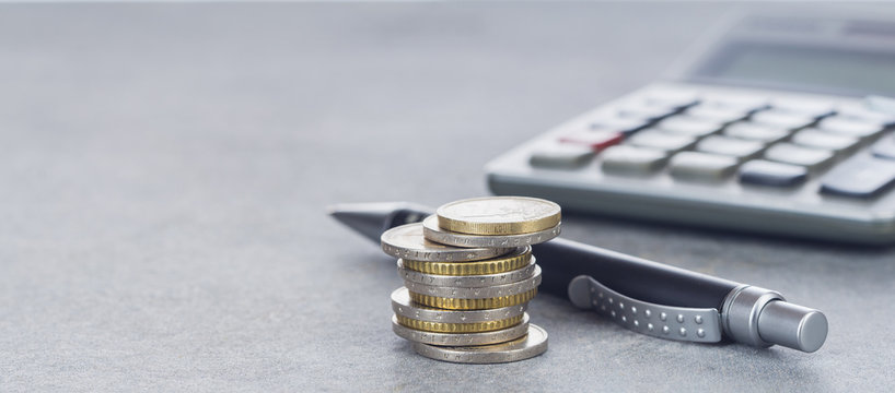 Finanzen, Euro, Stapel von Eurom&uuml;nzen, Kugelschreiber und Taschenrechner auf Schreibtisch, Hintergrund, Panorama