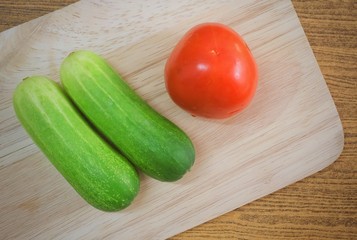 Fresh Tomato with Cucumbers on Cutting Board