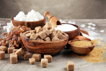 Various types of sugar, brown sugar and white on table