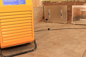 Luftentfeuchter und Wandtrockner im feuchten Zimmer