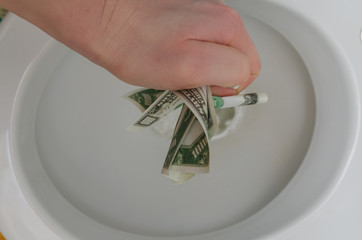 over the toilet hand with a thousand dollars