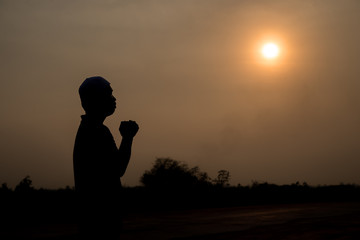 Fototapeta premium Silhouette Young asian muslim man praying on sunset,Ramadan festival concept