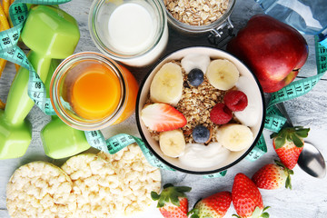 muesli with dairy and fruit, healthy lifestyle. bowl of cereal, fruit and dumbbell