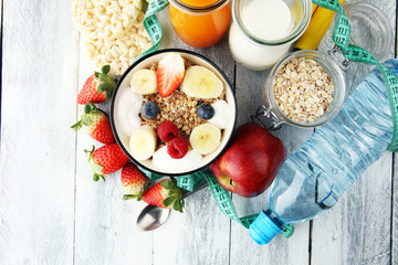 muesli with dairy and fruit, healthy lifestyle. bowl of cereal, fruit and dumbbell