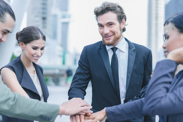 Professional business team joining stack hands and show hands together corporate meeting teamwork in cityscape background