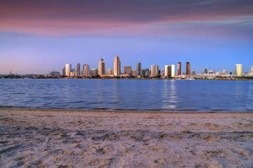 Naklejka premium The sunset over the San Diego skyline across San Diego Bay from Coronado Island.