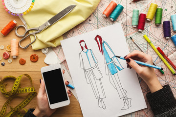 Top view on woman designer drawing clothes sketches