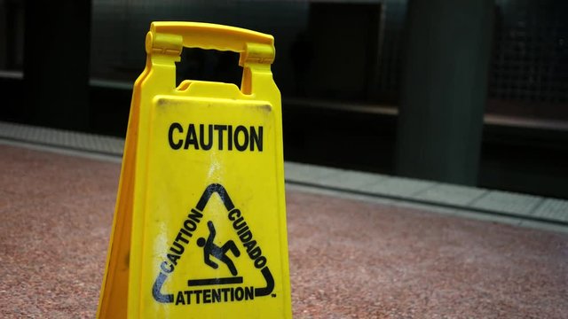 Close up of a caution sign near the train tracks of a subway station