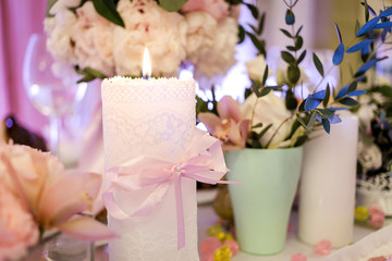 flowers in a vase and burning candle on a buffet table