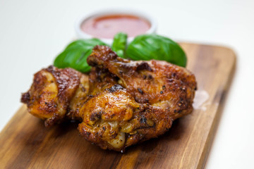 Chicken wings with sweet chilli sauce on the wooden cutting board