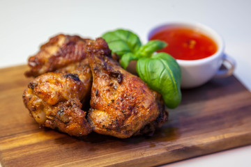 Chicken wings with sweet chilli sauce on the wooden cutting board