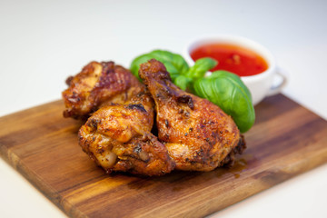 Chicken wings with sweet chilli sauce on the wooden cutting board