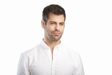 Young man portrait. Relaxed young businessman wearing shirt while standing against at isolated white background with copy space. 