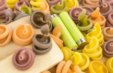 Obraz na płótnie Canvas Multicolored pasta and two batteries. The concept of energy in food. on a wooden background.