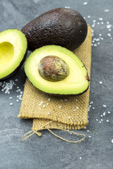 Fresh avocado on black old wooden table.