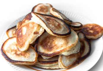 Freshly roasted appetizing pancakes with crispy crust on a white saucer