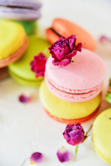 Delicate Fresh Colorful French Macaroons In Pastel Colors With Flowers Roses On A Light Textile Background