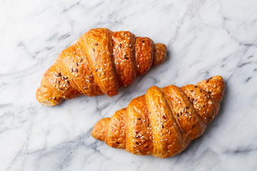 Croissants on marble table. French traditional pastry. Top view