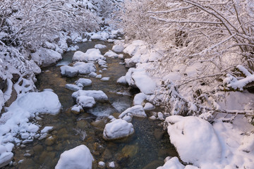 Winter idylle mit schnee und Wasser im Bach