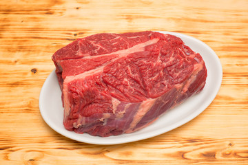 steak fat beef  with white plate and old wooden board