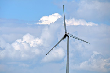 wind turbine with blue sky and fluffy cloud background