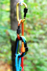 Carabiner with rope on nature background.