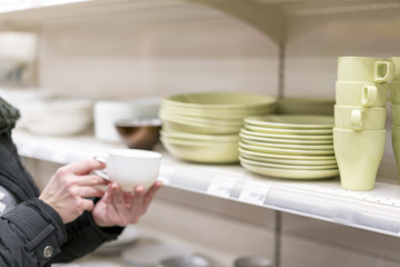 A woman choosing a cup in a crockery store