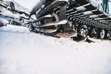 Close up view of special snow vehicle with the caterpillar on the snow in winter.