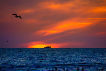 Fototapeta na wymiar Sonnenuntergang und Schiff am Meer