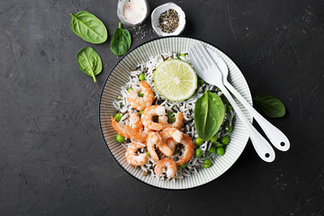 Healthy easy food. Wild rice and basmati rice with young green peas, royal prawns and yellow cherry tomatoes in white serving bowl. Top View. Flatlay.