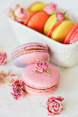 Dessert: A Delicate Fresh Colorful French Macaroons In Pastel Colors Gift Box Flowers Roses On Light Textiles Background