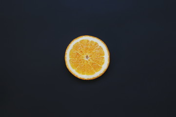 Single orange fruit on black background. Slice fruit wallpaper