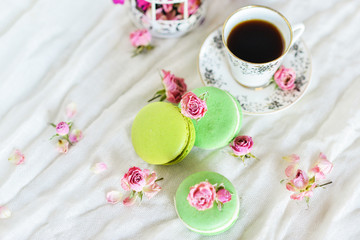 Delicate Fresh Colorful French Macaroons In Pastel Colors With Flowers Roses On A Light Textile Background