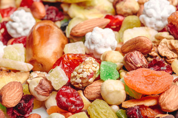 Tasty sweet mix dried fruits colorful background. A set of textures of nuts, legumes and dried fruits. 
