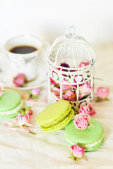 Dessert: A Delicate Fresh Colorful French Macaroons In Pastel Colors With Flowers Roses On A Light Textile Background, Top View