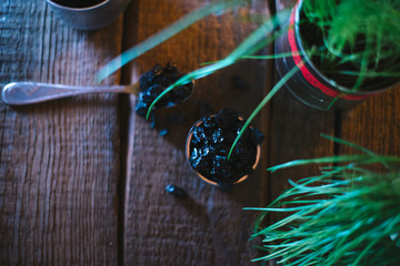 Still life of grapes and prunes on a wooden background.