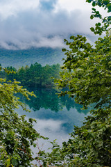 Obraz premium Blue karst lake, reflection of green foliage on the water