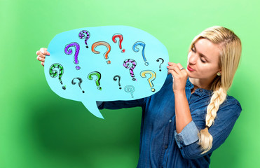 Question marks with young woman holding a speech bubble