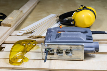 Carpentry tools on a wooden workshop table. Saw and other carpentry accessories while working in a...