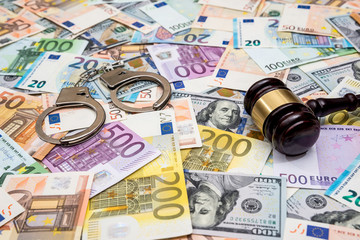 crime concept - handcuffs, gavel dollar and euro bills