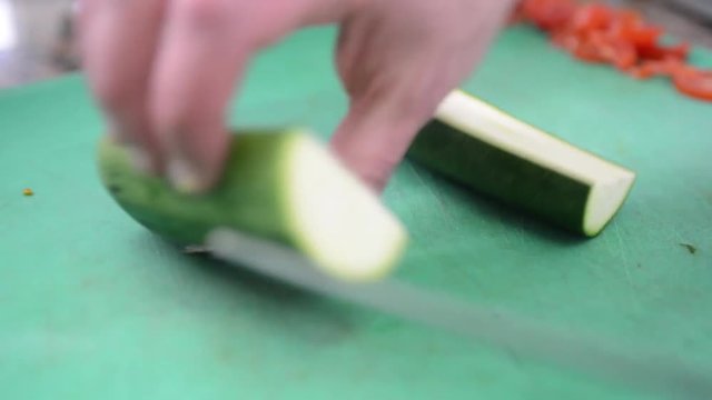 cuoco taglia le zucchine in una cucina di un ristorante